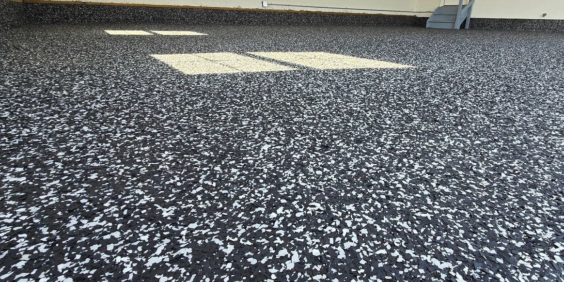 Black-and-white decorative flake floor with sunlight from a DiFranco Epoxy project