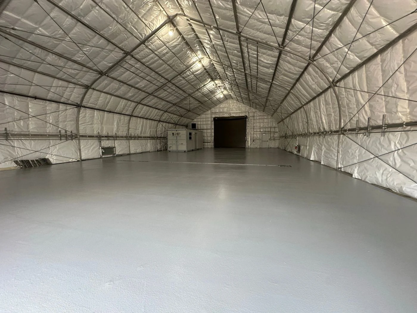 Gray commercial floor inside an insulated arched warehouse
