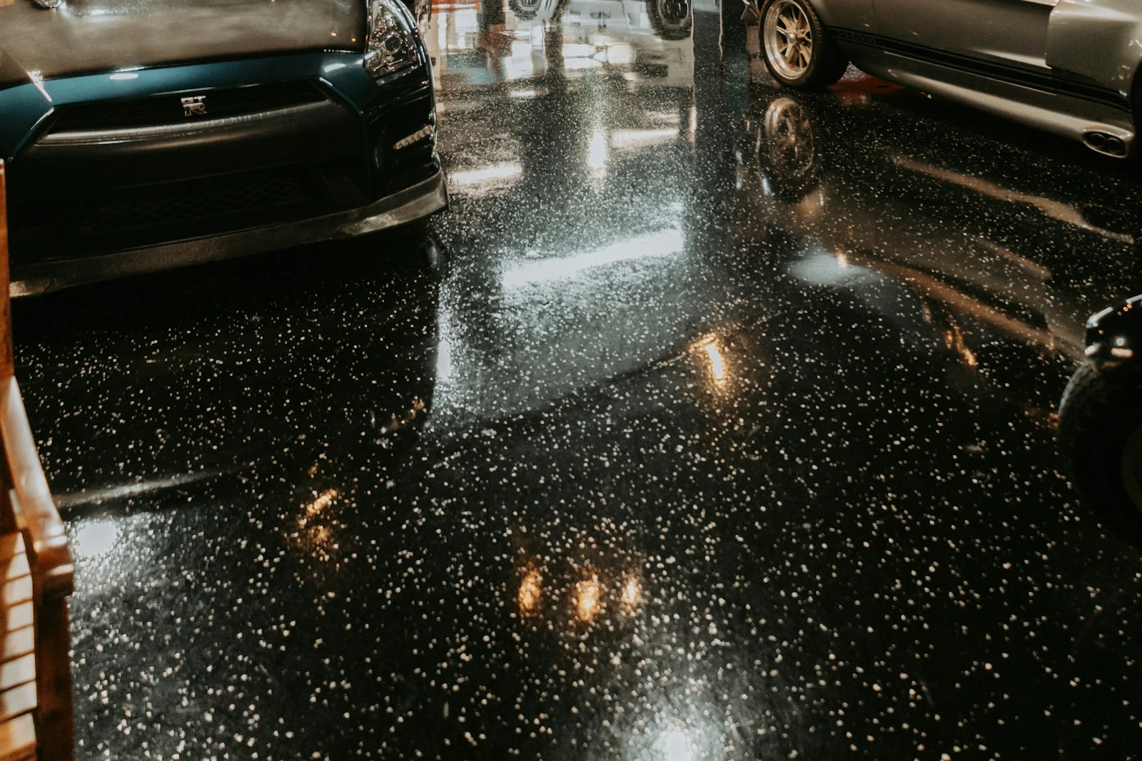 Black decorative flake floor with white chips and glossy reflections in a classic-car garage
