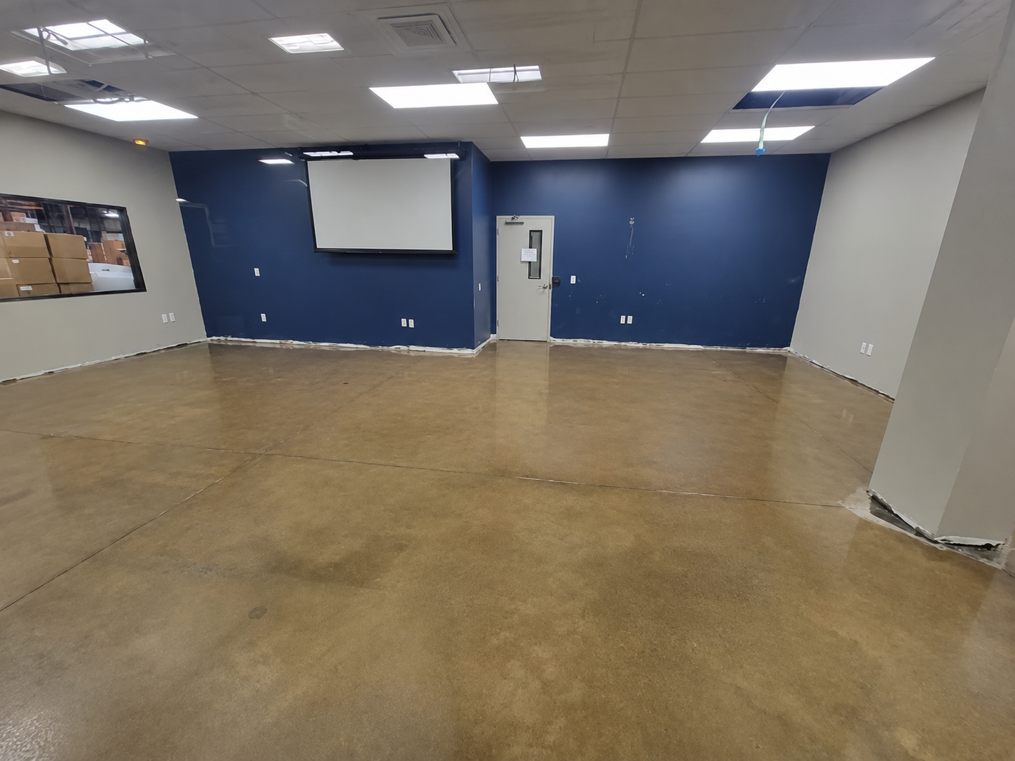 Glossy concrete flooring in a commercial room with blue and gray walls