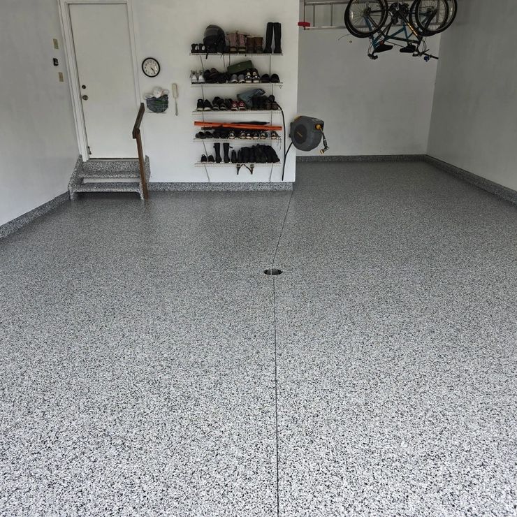 Gray decorative flake garage floor with wall storage and bicycles