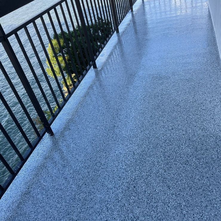 Blue-gray decorative flake porch floor beside a black railing